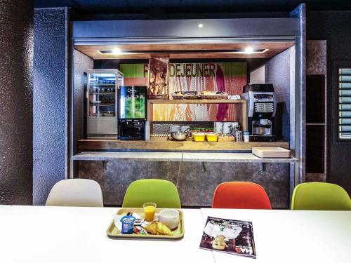 cocina con encimera con mesa y sillas en Ibis budget Périgueux, en Périgueux