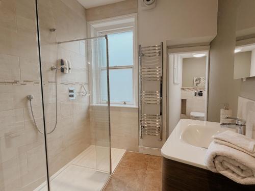 a bathroom with a shower and a sink at The Roman Kove Apartment Bath in Bath