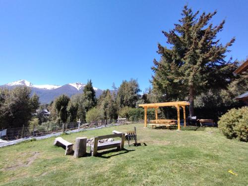 a park with benches and a gazebo in the grass at Huerta de los Andes - Bed and Breakfast in Villa La Angostura