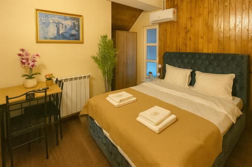 a bedroom with a bed with two towels on it at Airport 179A in Otopeni
