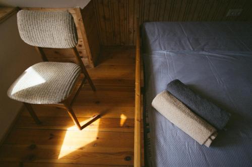 a bedroom with a bed and a chair next to it at Viesu nams Melnsils in Melnsils