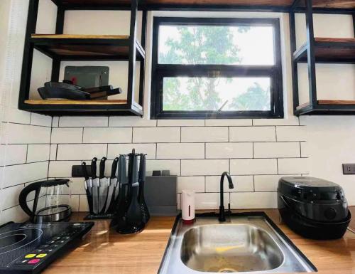 a kitchen counter with a sink and a window at Balai Halang in Palavit