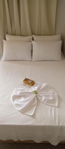 ein weißes Bett mit einem weißen Kleid darauf in der Unterkunft Hotel Comodoro in Comodoro
