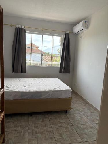 a bedroom with a bed and a window at apartamento lindo com 2 quartos in Itapoa