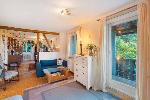 a living room with a blue couch and a window at Ferienwohnung Spiritbalance in Sasbachwalden