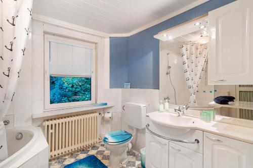 a bathroom with a toilet and a sink and a window at Ferienwohnung Spiritbalance in Sasbachwalden
