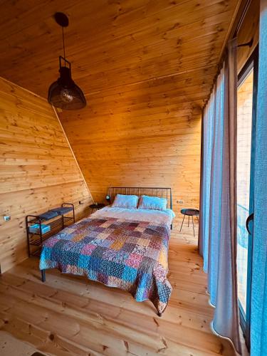a bedroom with a bed in a wooden cabin at Wild Escape Racha in Ambrolauri