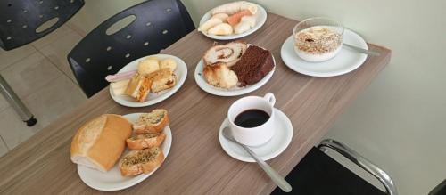 una mesa con platos de comida y una taza de café en Hotel Comodoro, en Comodoro