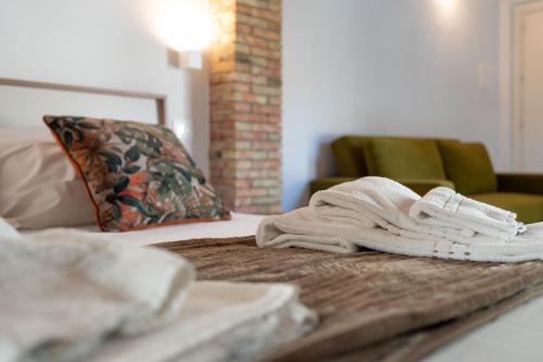 a pile of towels on a bed with a couch at Dimora Lincoln in Grotte