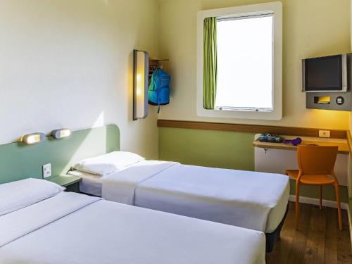 een hotelkamer met twee bedden en een raam bij ibis budget Rio de Janeiro Centro in Rio de Janeiro