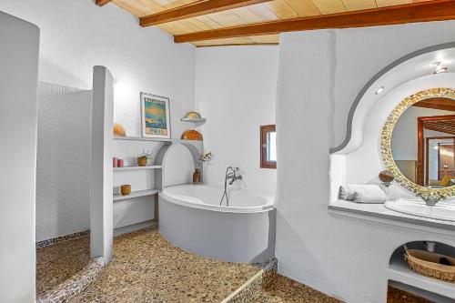 a bathroom with a tub and a sink and a mirror at Chalet Las Canas in Santa Maria del Camí