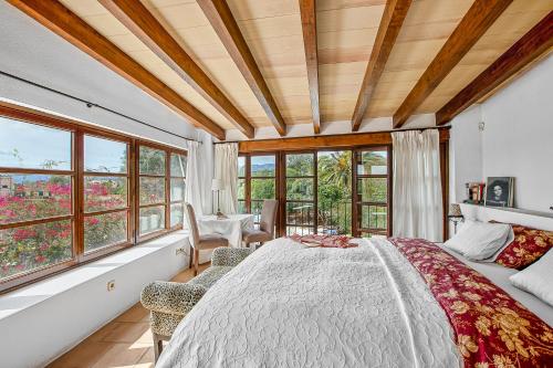 a bedroom with a large bed and windows at Chalet Las Canas in Santa Maria del Camí