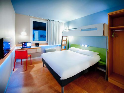a bedroom with a bed and a desk with a computer at ibis budget Brest Centre Port in Brest