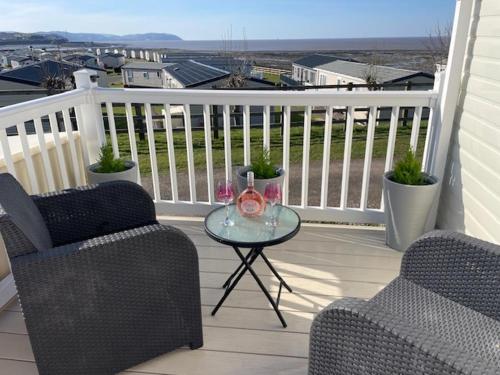 a balcony with two chairs and a glass table at Cabin - Sleeps 4 - Pets Ok - Balcony - Parking in Watchet