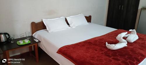 Un dormitorio con una cama con dos animales de peluche encima. en RN guest house, en Arambol