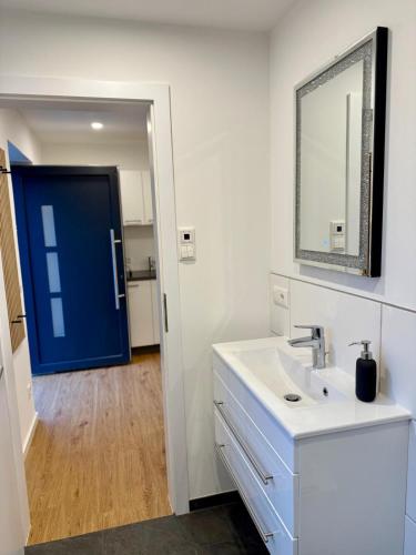 a bathroom with a sink and a blue door at NNN - NigelNagelNeu in Celle
