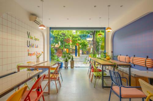 a restaurant with tables and chairs and a large window at Leng x Vuishare - Ecopark with working space in Kim Quan
