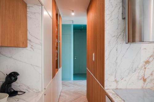 een keuken met witte marmeren muren en een hal bij Luxury Yacht Park Apartment Marina View Gdynia Free Parking in Gdynia