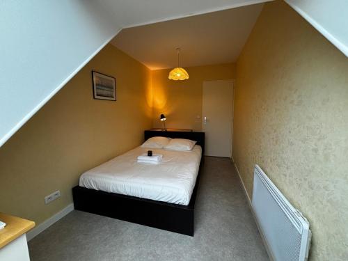 a bedroom with a bed with a laptop on it at L'ALTÉA - top floor - bright - city center in La Roche-sur-Foron