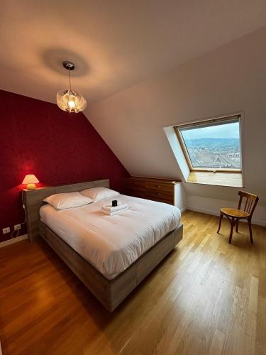 a bedroom with a large bed and a window at L'ALTÉA - top floor - bright - city center in La Roche-sur-Foron