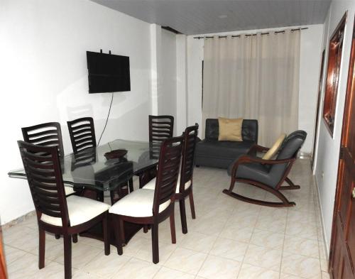Una sala de estar con una mesa y sillas y un sofá. en CASA VACANZA Cenaida Mono Titi, en Leticia