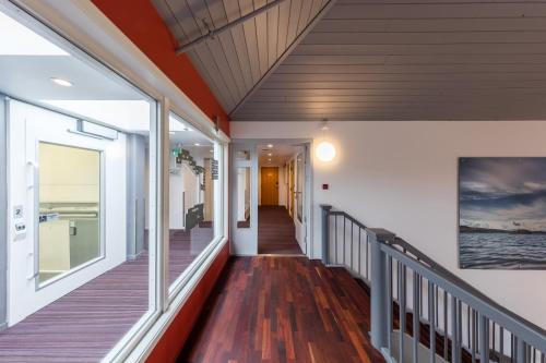 a hallway of a home with wood flooring and windows at Dolmsundet Hotell Hitra in Melandsjøen