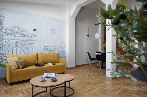 a living room with a yellow couch and a table at Art Palace - Fragola Apartments in Kraków