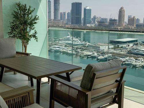 a table and a bench and a view of a harbor at Glamorous 3BR with Marina view in Dubai