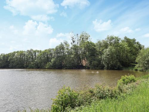 a lake with trees on the side of it at Sumner Lodge in Kyre Magna