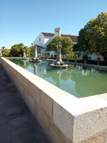 a stone wall with three statues in a fountain at CiTY CENTER in Castelo Branco