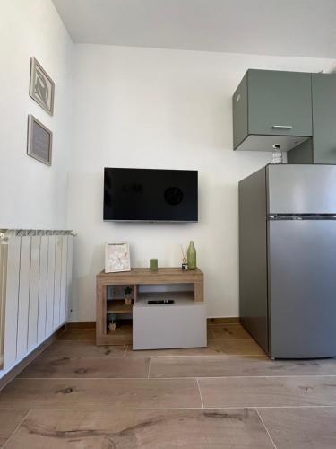 a kitchen with a refrigerator and a tv on the wall at Casa Amali in Intra