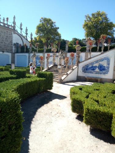 a garden with hedges and a staircase with statues at CiTY CENTER in Castelo Branco
