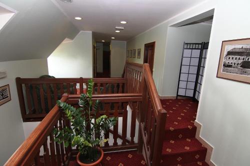 a staircase with wooden railings and a plant at Zámek Havířov in Havířov