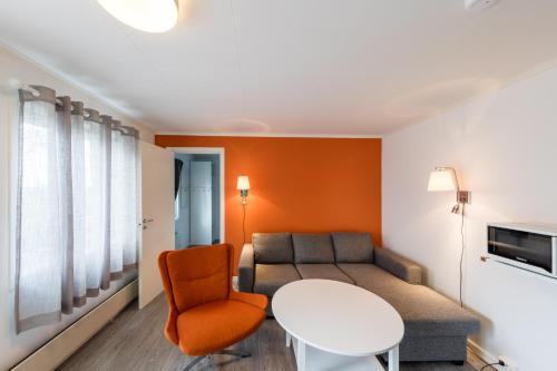 a living room with a couch and a table at Dolmsundet Hotell Hitra in Melandsjøen