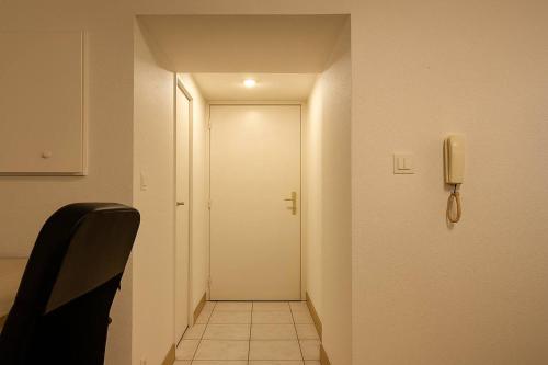 a hallway with a white door and a phone on the wall at Studio Maison de Maître, Parking sur Place privé Free, MULHOUSE CENTRE in Mulhouse