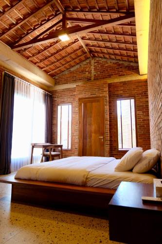 a bedroom with a large bed in a brick wall at Pulojava Resort in Karimunjawa