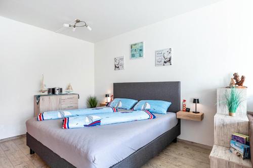 a bedroom with a large bed with blue pillows at Kleine Auszeit am Meer in Büsum