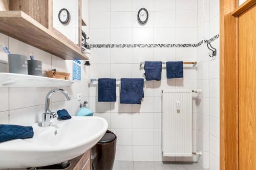 a bathroom with a white sink and blue towels at Kleine Auszeit am Meer in Büsum