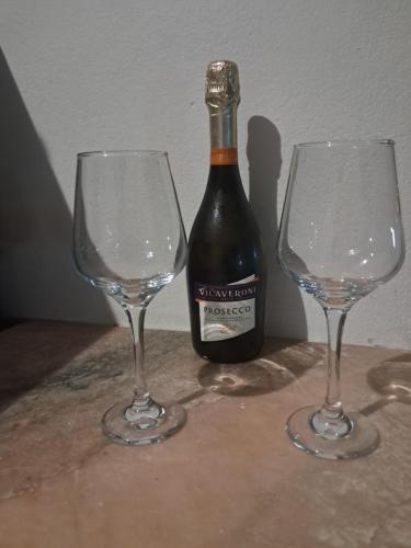 two empty wine glasses next to a bottle of wine at Sinagoga Guesthouse in Ribeira Grande