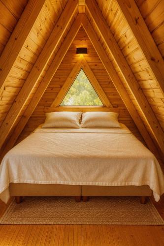 a bed in a wooden room with a window at La Bella Bungalov in Dosemealti