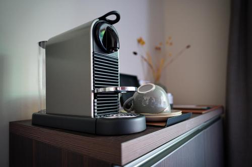 a table with a tv and a tea kettle on it at MÍMESIS 11 - Boutique Hotel in Como