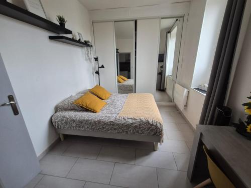 a bedroom with a bed with yellow pillows on it at Studio Cosy - Manoir Securisé - Avon in Avon