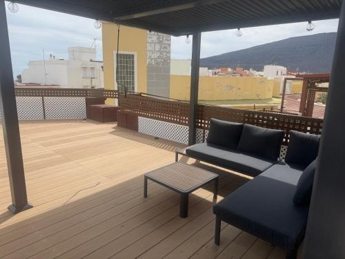 a balcony with a couch and a table on a roof at Casita La Mercería in Güimar