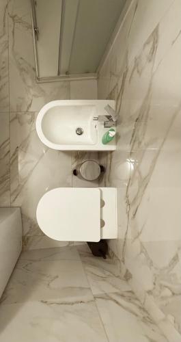 a white bathroom with a sink and a toilet at The Dream Home in Vieste