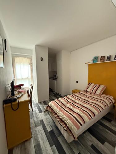 a bedroom with a large bed and a desk at La Résidence du Moulin in Jonzac