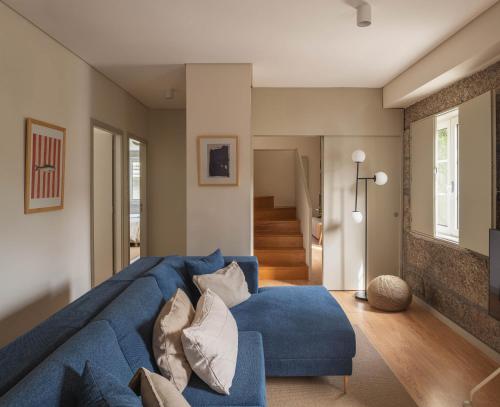 a living room with a blue couch and a hallway at Casa da Ponte in Amarante