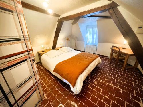 a bedroom with a bed and a table and a desk at Le clos des écureuils in Amboise