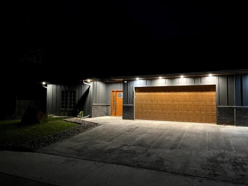 a building with a garage with a orange door at night at Newly built home in Superior Duluth area in Superior