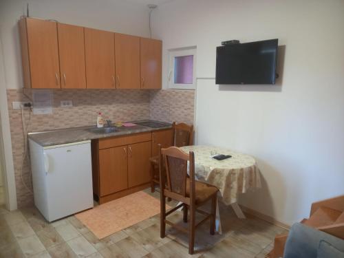 Il comprend une cuisine équipée d'une petite table et d'un réfrigérateur blanc. dans l'établissement Marija apartmani, à Kraljevo