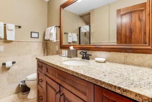 a bathroom with a sink and a mirror and a toilet at Ski In, Ski Out 3 Bedroom Condo At The Eagle Bahn Gondola With Slopeside Pool in Vail